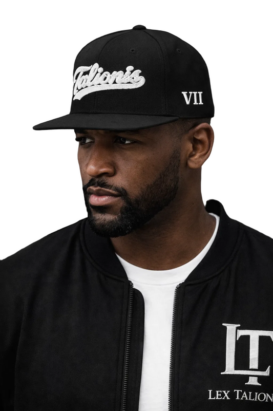Man wearing a black cap and jacket with 'Lex Talionis' branding on a dark background