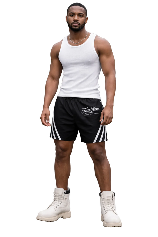 Man wearing a white tank top and black shorts with white stripes, standing outdoors.