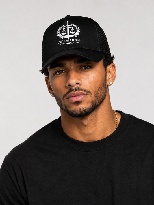Man wearing a black cap with a logo and text on a plain background