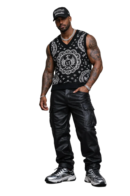 Man wearing a black bandana-patterned tank top, black cargo pants, and black sneakers on a gray background