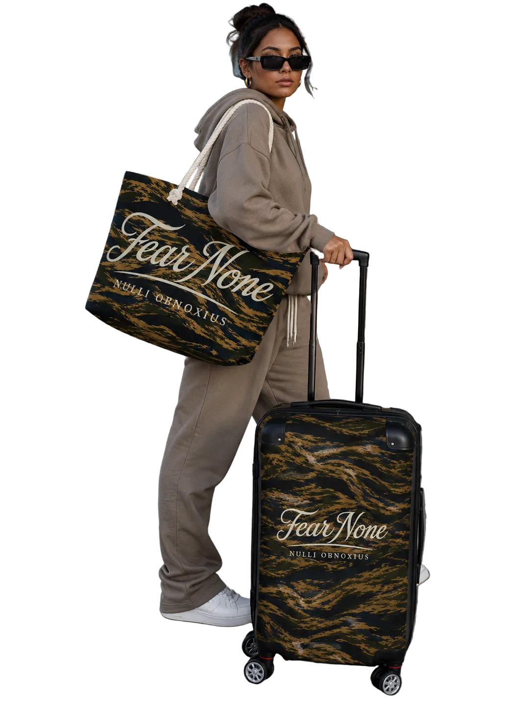 Person holding a 'Fear None' bag and suitcase at an airport.