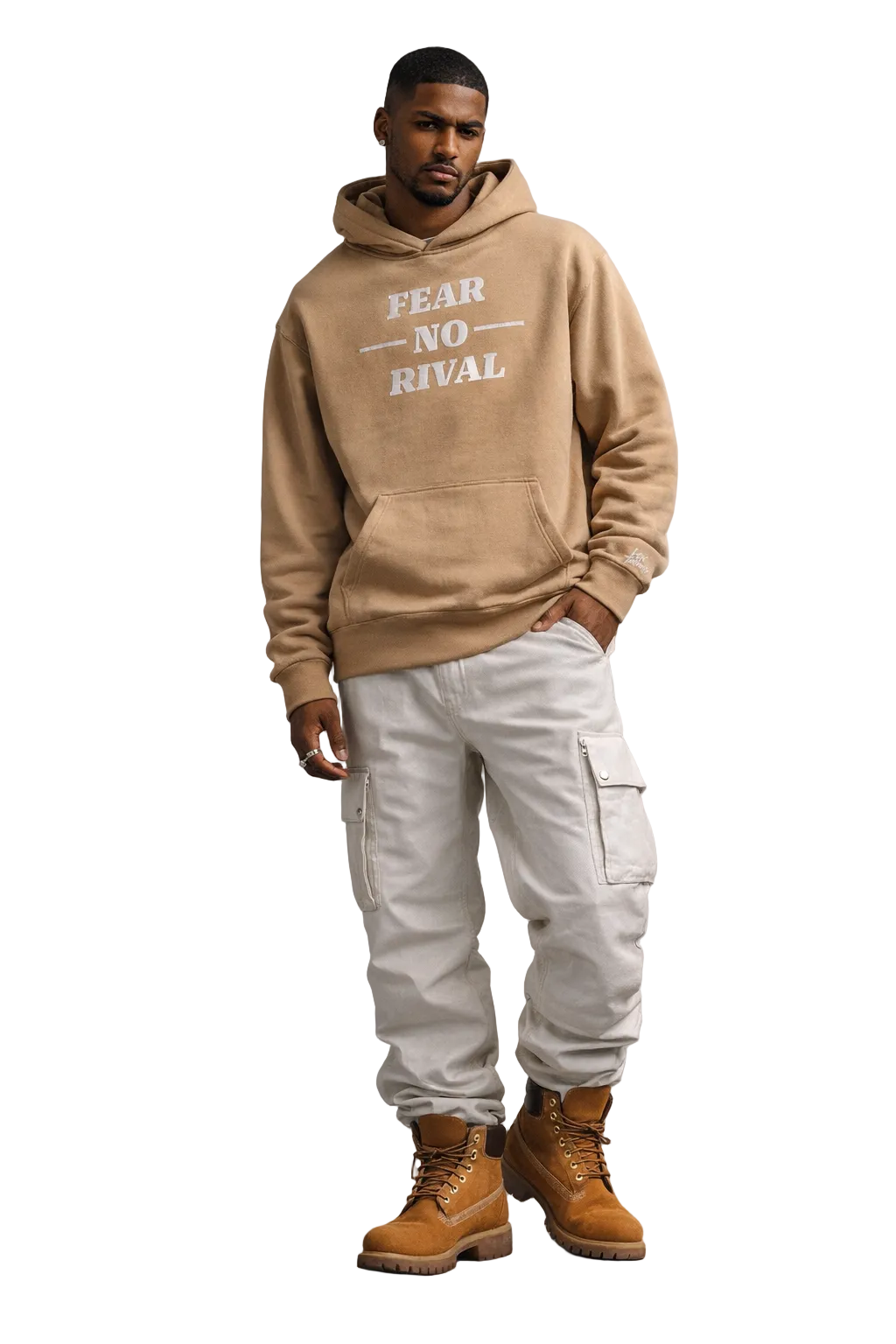 Man wearing a beige hoodie with 'FEAR NO RIVAL' text, white cargo pants, and brown boots against a gray background.