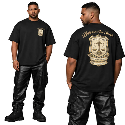 Man wearing a black t-shirt with a logo on the front and back, standing against a gray background.