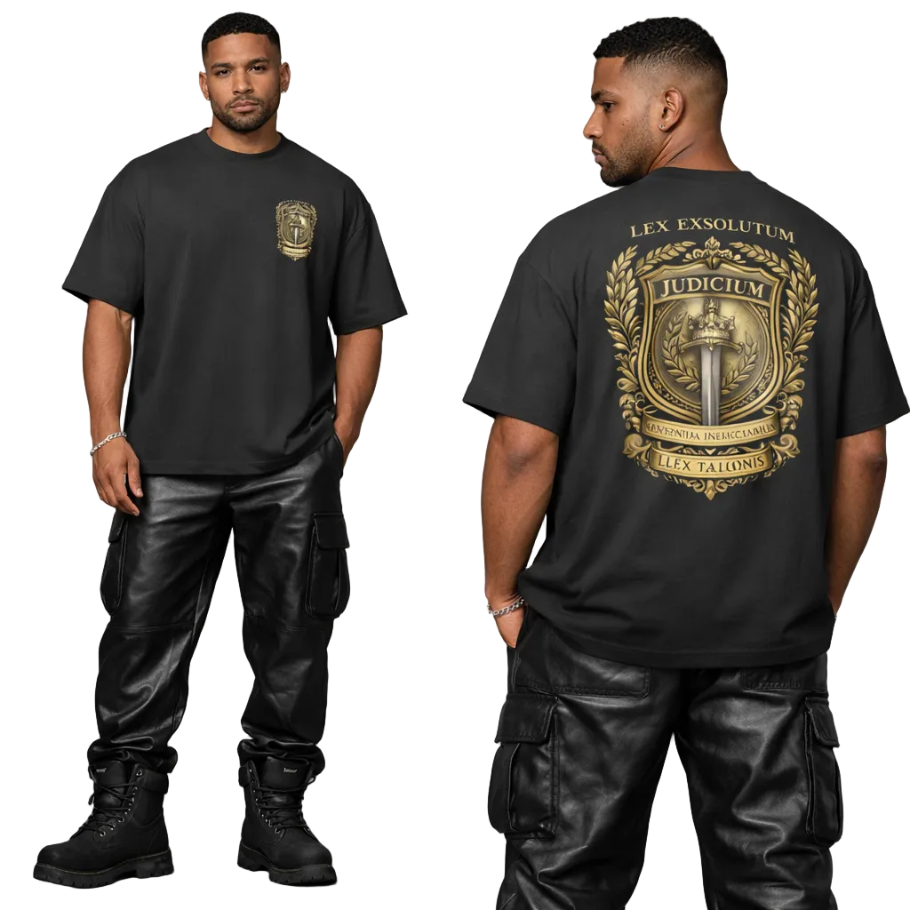 Man wearing a black t-shirt with a gold emblem and text, standing against a gray background.