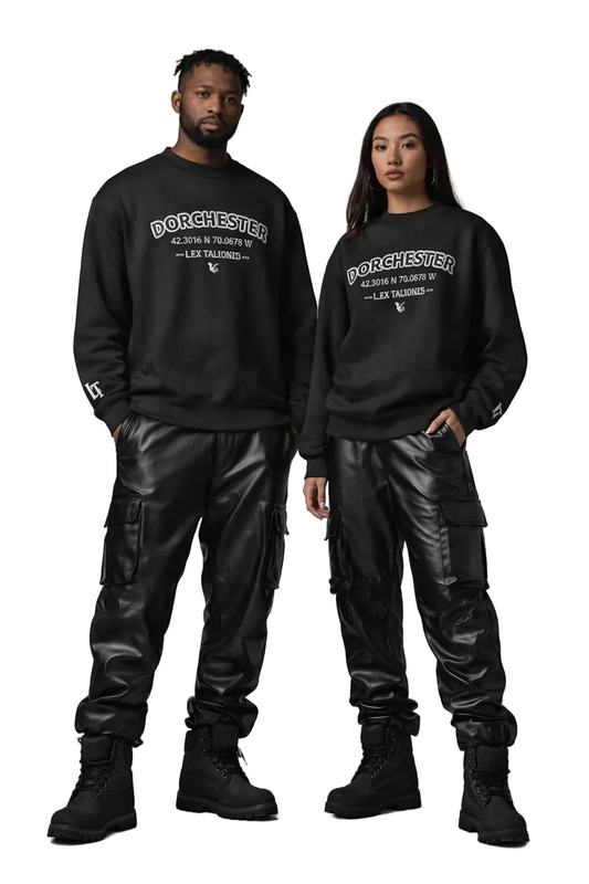 Two people wearing black sweatshirts with 'Dorchester' text, standing against a gray background.
