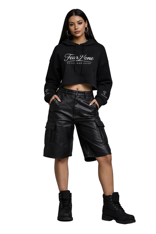 Person wearing a black hoodie with 'Four Tone' branding and black leather shorts on a gray background