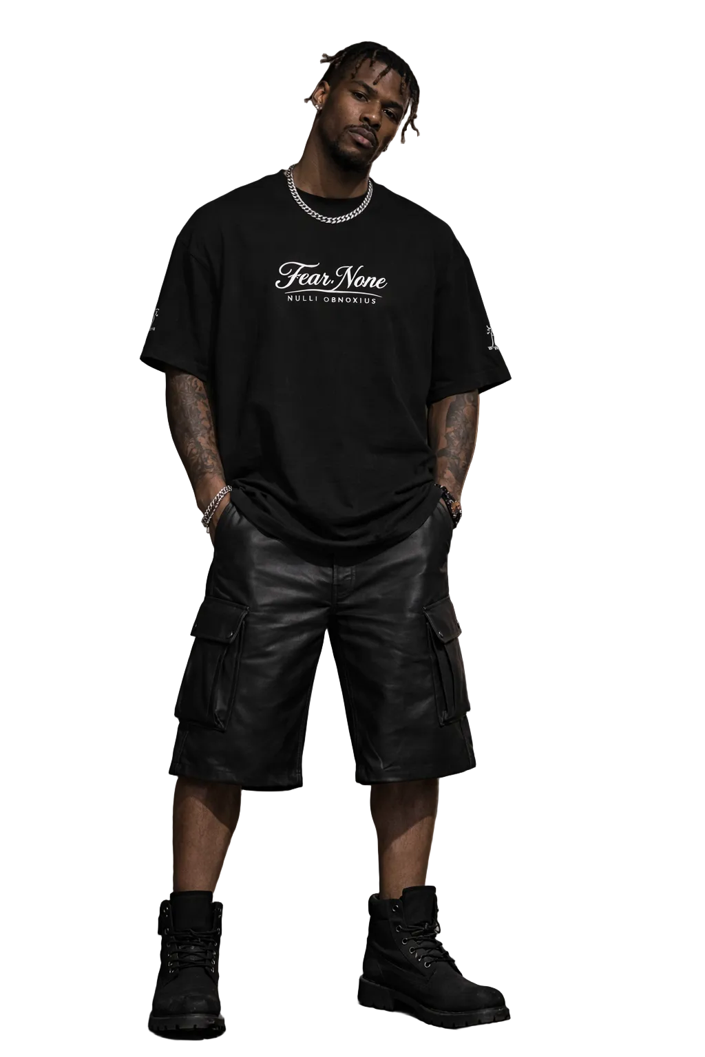 Man wearing a black t-shirt with 'Fear None' text, leather shorts, and black boots in an urban setting.