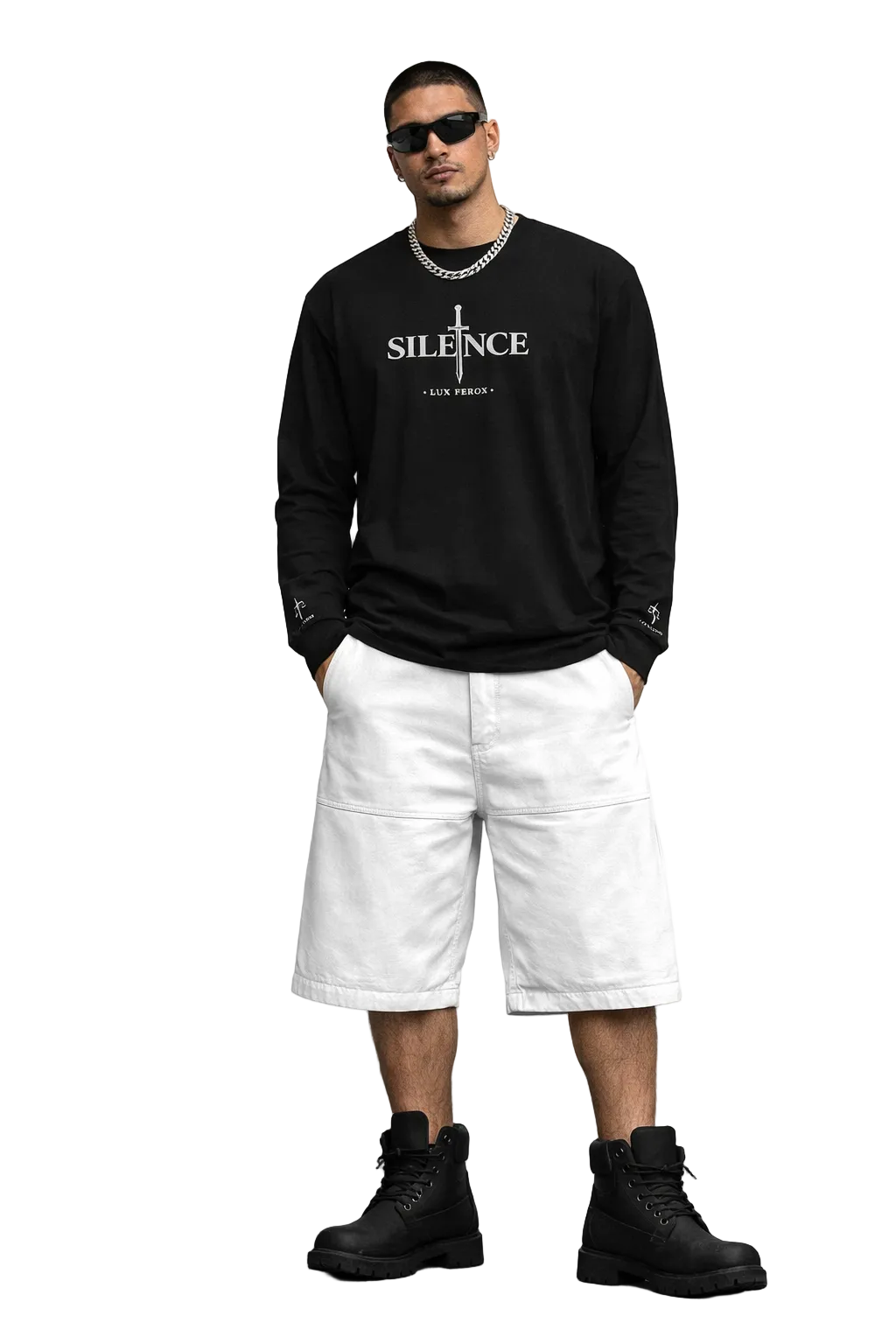 Man wearing a black sweatshirt with text, white shorts, and black boots on a plain background