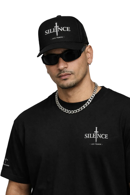 Man wearing a black cap and sunglasses with 'SILENCE' branding on a light gray background