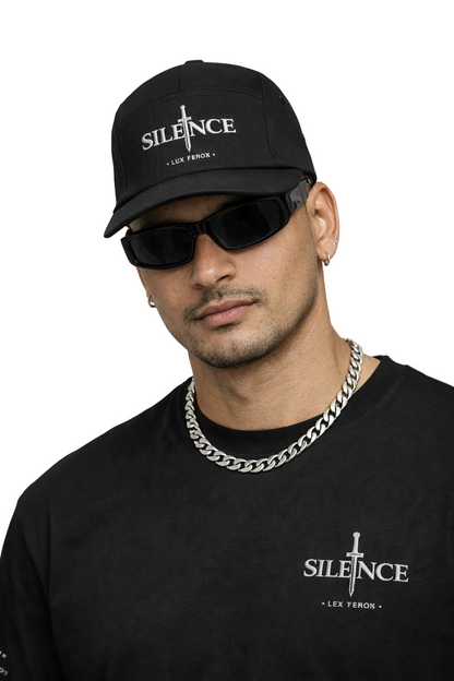 Man wearing a black cap and sunglasses with 'SILENCE' branding on a white background