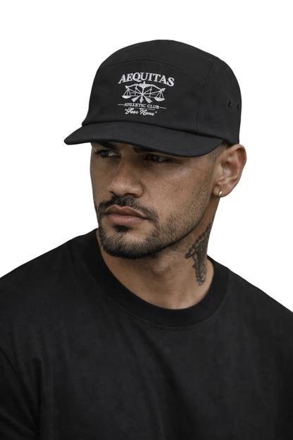 Man wearing a black cap with 'Aequitas' logo against a gray background