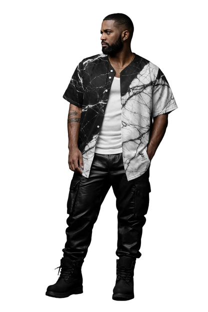 Man wearing a marble-patterned shirt and leather pants against a dark background