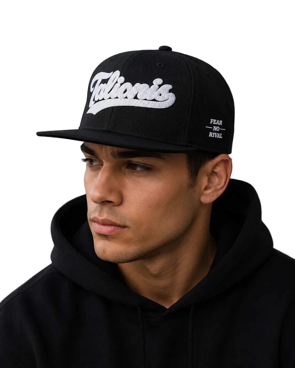 A man wearing a black snapback cap with a white 'Talionis' logo on the front and 'FEAR OF GOD' on the side, paired with a black hoodie against a concrete wall.