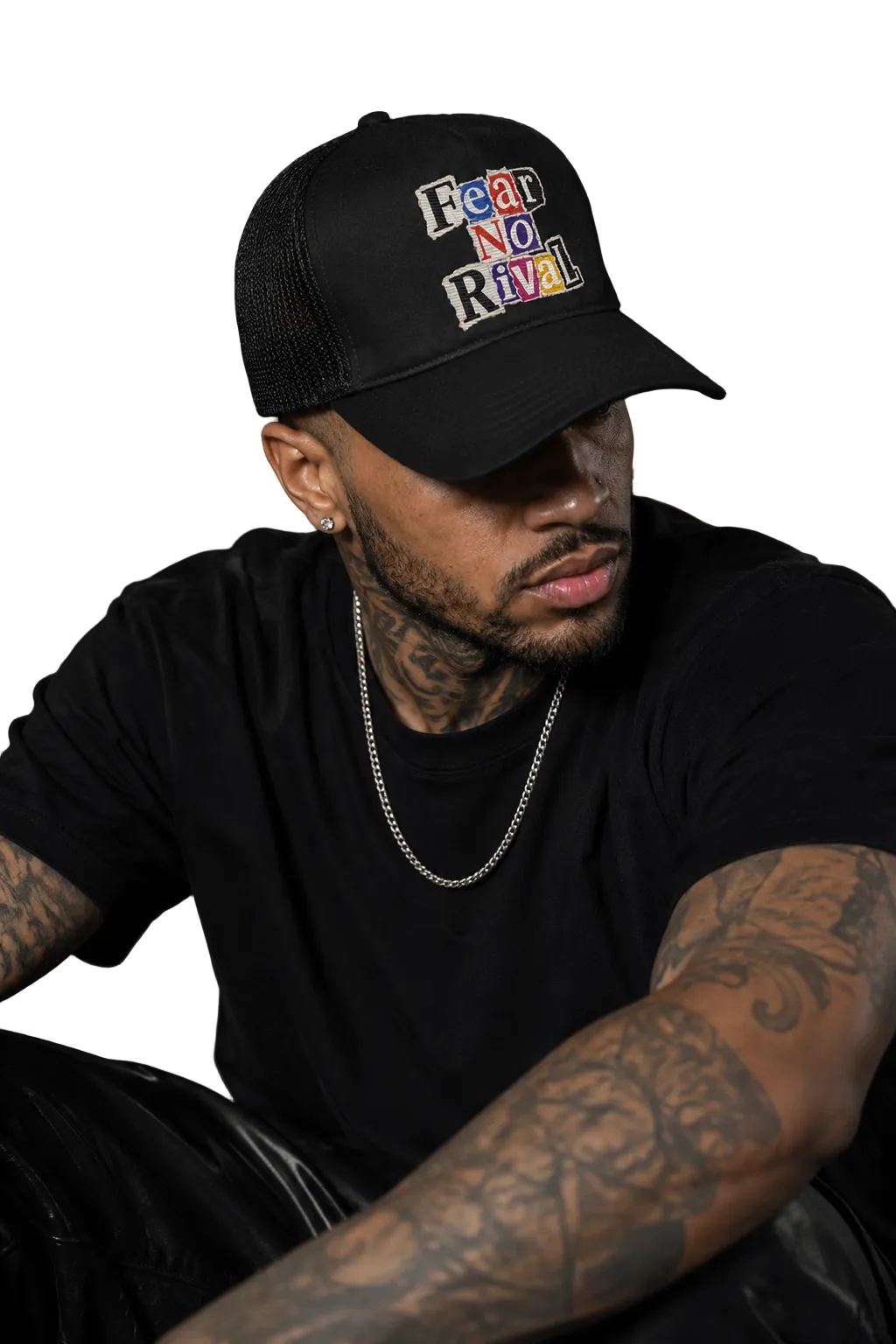 A man wearing a black trucker hat with the embroidered text 'Fear and Loathing in Las Vegas' in a multicolor retro font, paired with a black t-shirt and silver chain necklace.