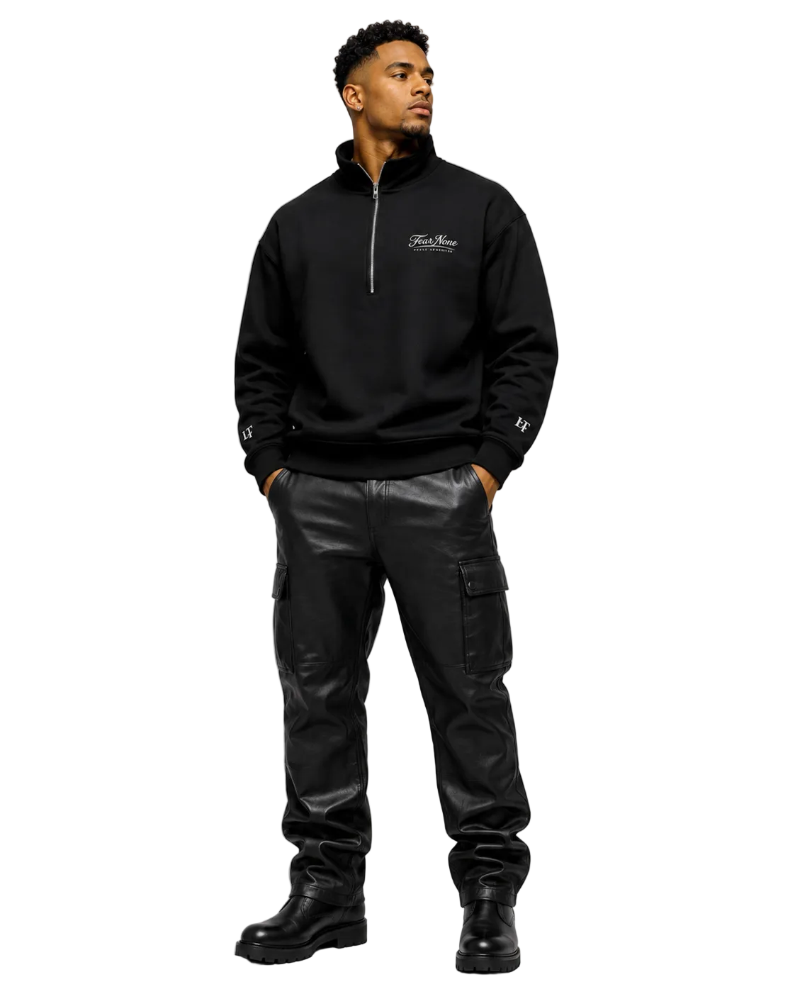 A man wearing a black half-zip sweatshirt with a small white chest logo, black cargo pants, and black boots, standing against a light gray studio background.