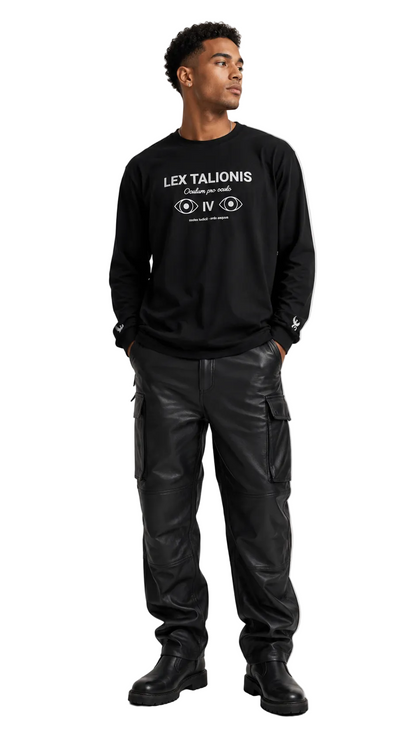 A man wearing a black crewneck sweatshirt with white graphic text and cargo pants, standing against a light gray studio background.