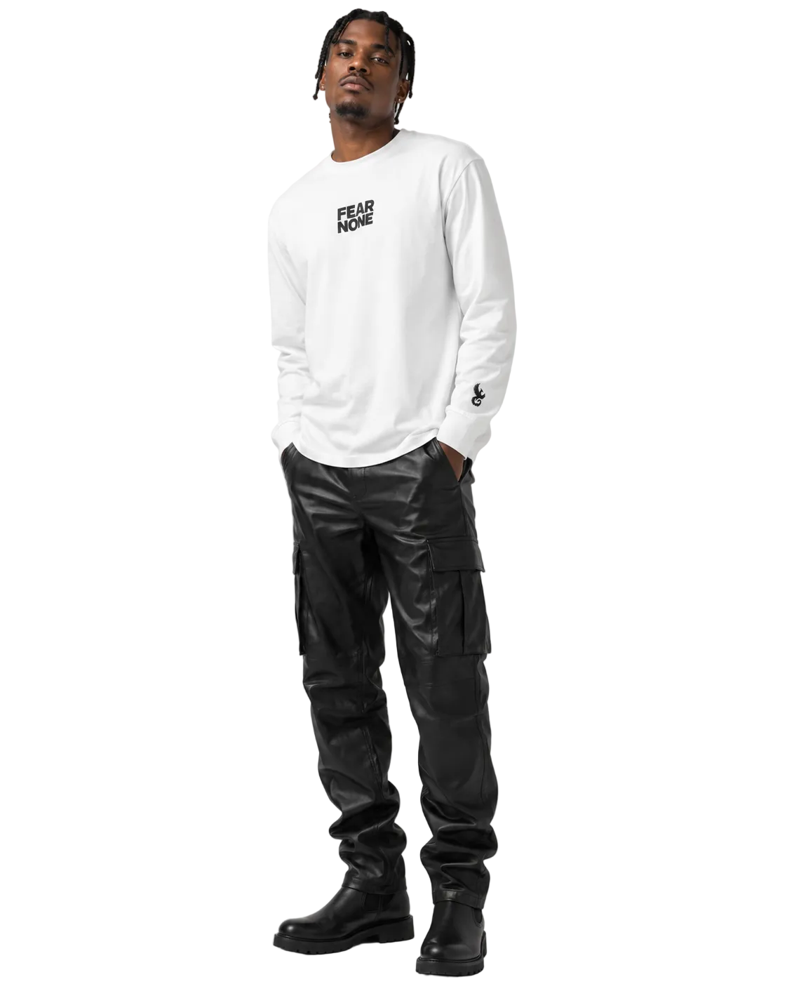 A man modeling a white long-sleeve crewneck shirt with a black 'FEAR NONE' logo on the chest, paired with black cargo pants and black boots, against a light gray studio background.