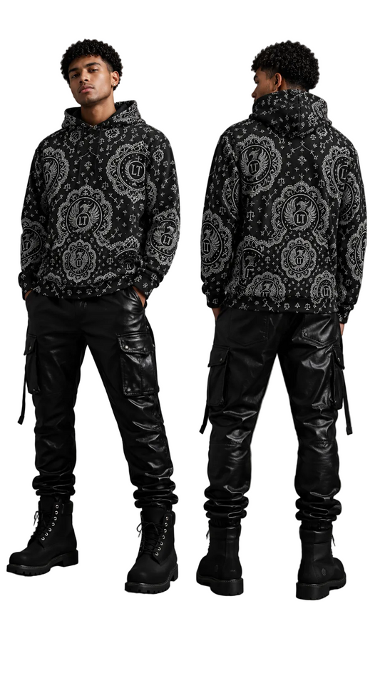Person wearing a black patterned hoodie and black leather pants on a gray background