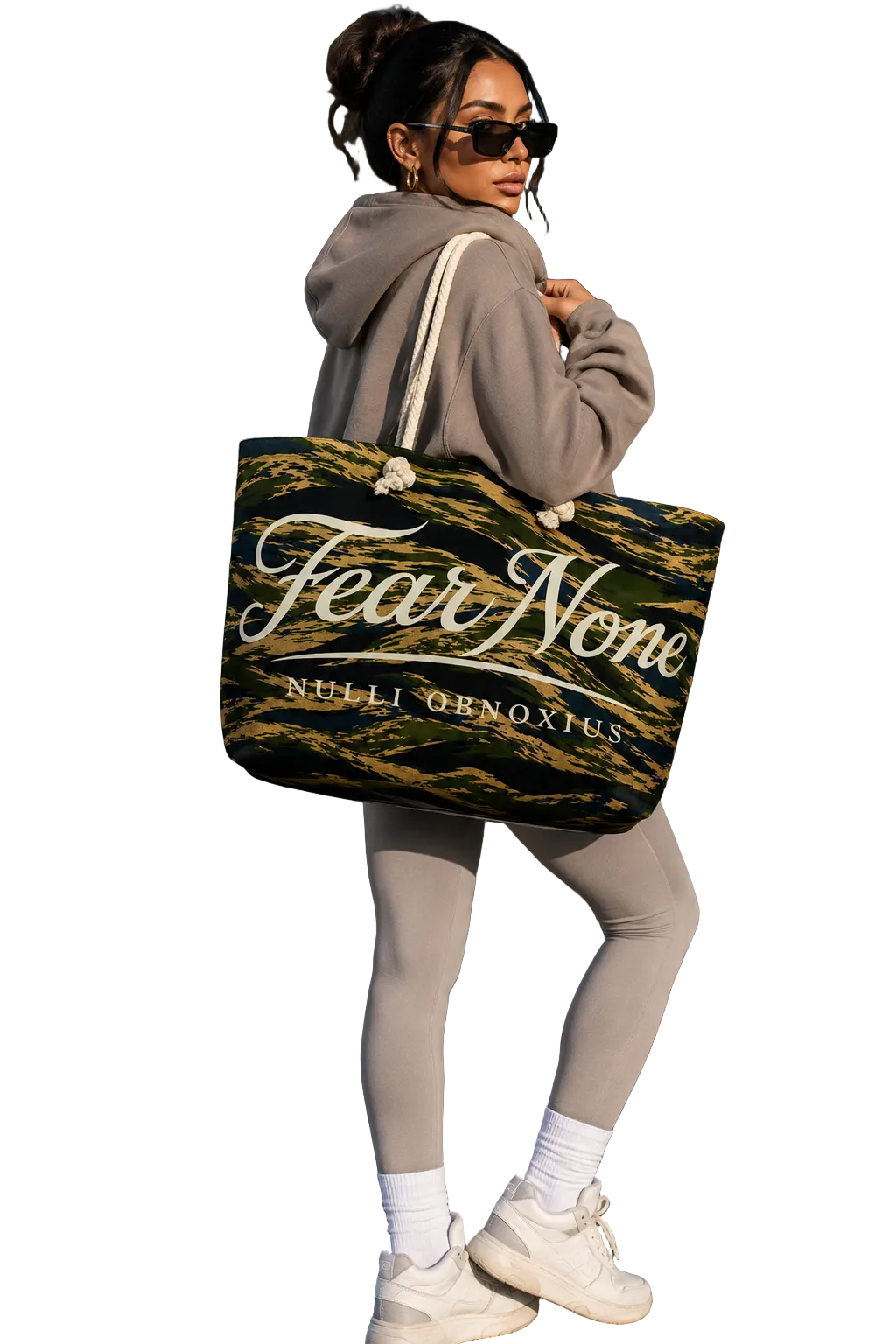 Person holding a tote bag with 'Fear None' text in an airport setting