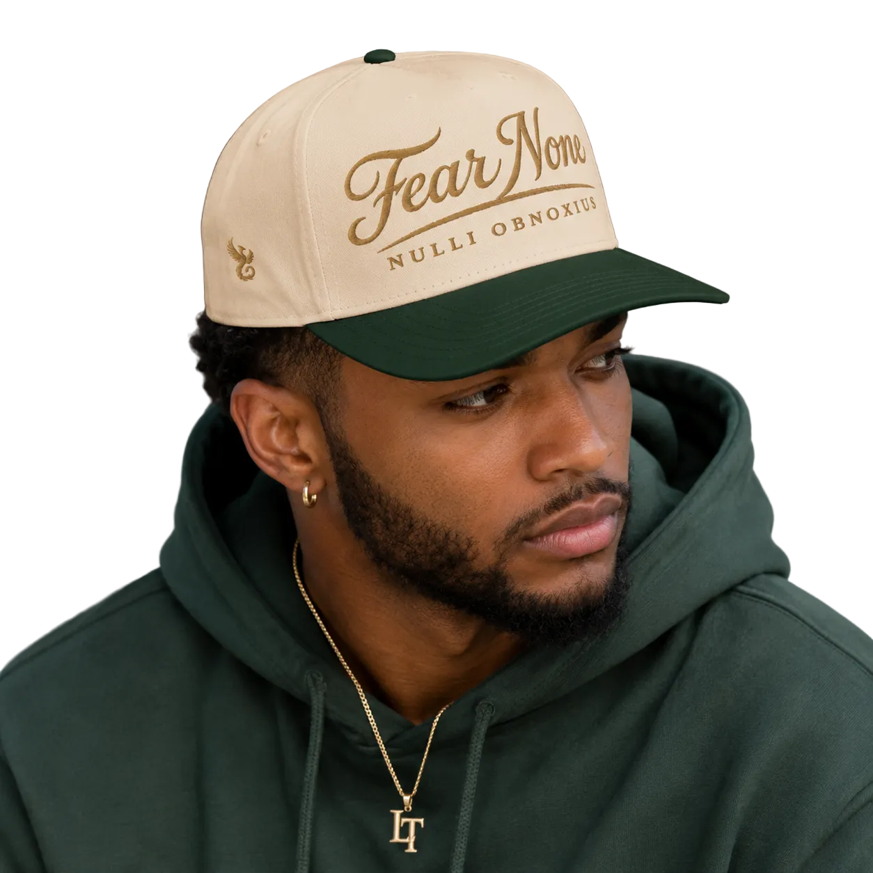 Man wearing a beige and green cap with 'Fear None Nulli Obnoxius' text, looking to the side.