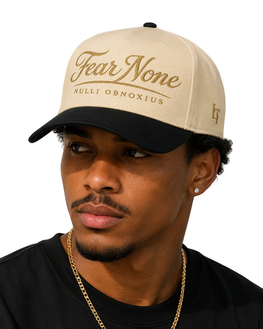 Man wearing a beige cap with 'Fear None' text on a plain background