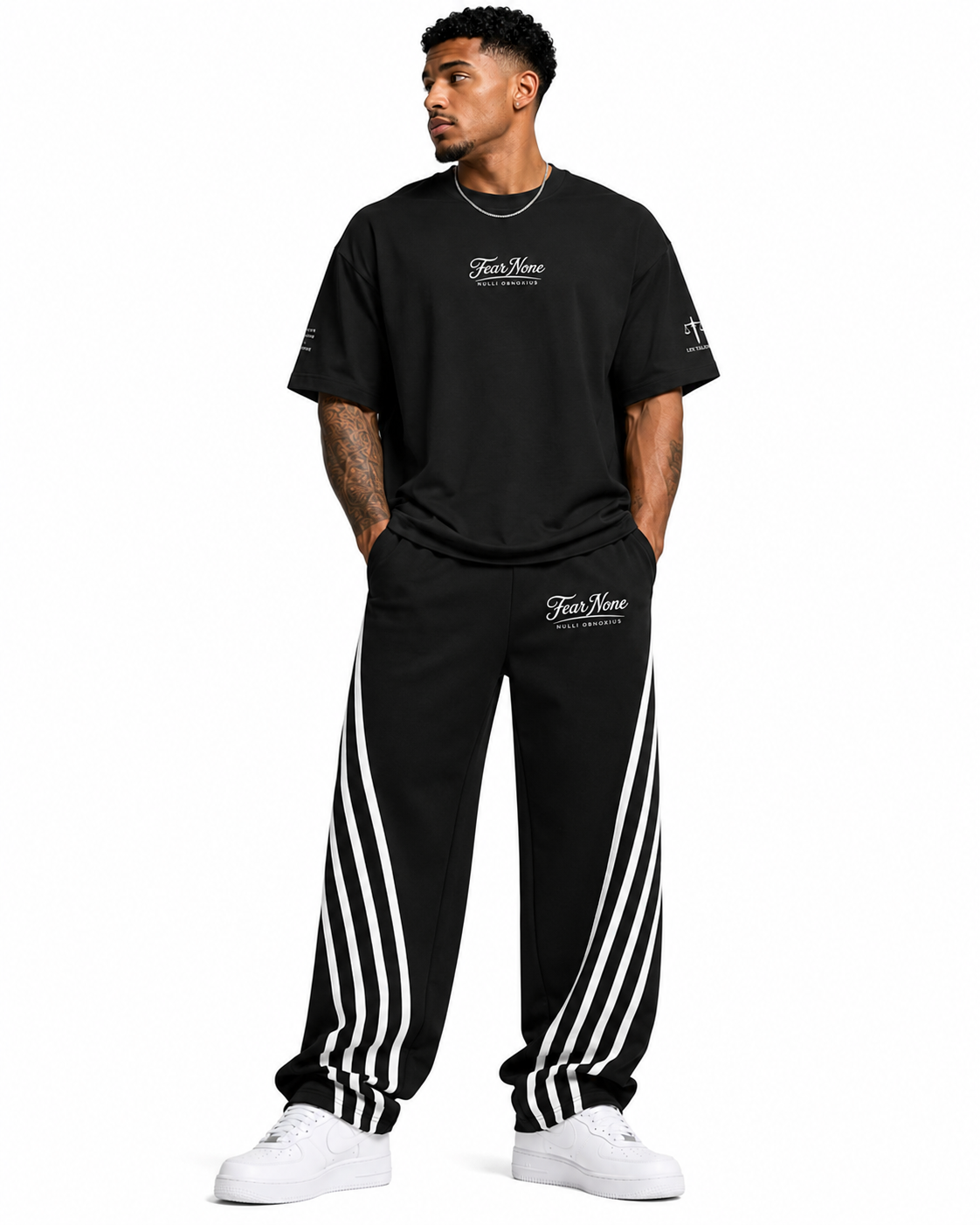 Man wearing a black t-shirt and black pants with white stripes on a white background